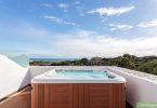 grand spa rigide de type jacuzzi installé sur une terrasse avec vue