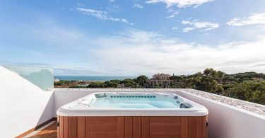 grand spa rigide de type jacuzzi installé sur une terrasse avec vue